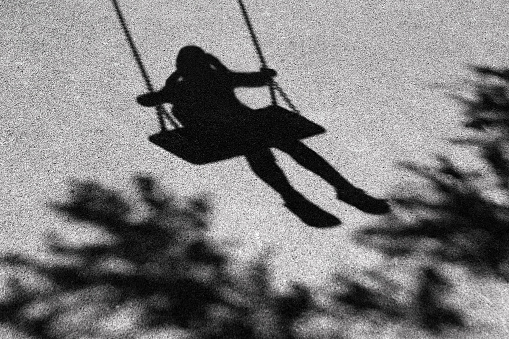 A shadow of a girl on a swing